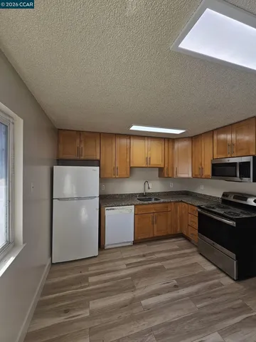 a kitchen with a sink a stove top oven and refrigerator