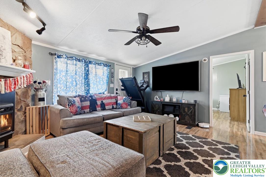 634 Main Road Lehighton, PA 18235 - Photo 13 of 39 A comforting living area showcasing a warm fireplace and a versatile overhead ceiling fan.