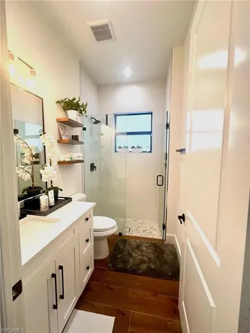 a bathroom with a double vanity sink mirror and toilet