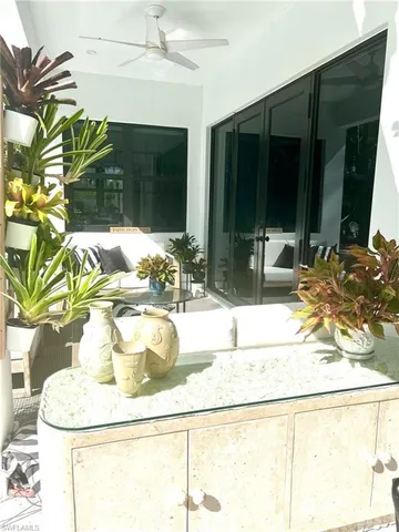 a view of a patio with table and chairs potted plants with wooden floor and fence