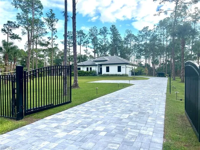 a view of a house with a yard and potted plants