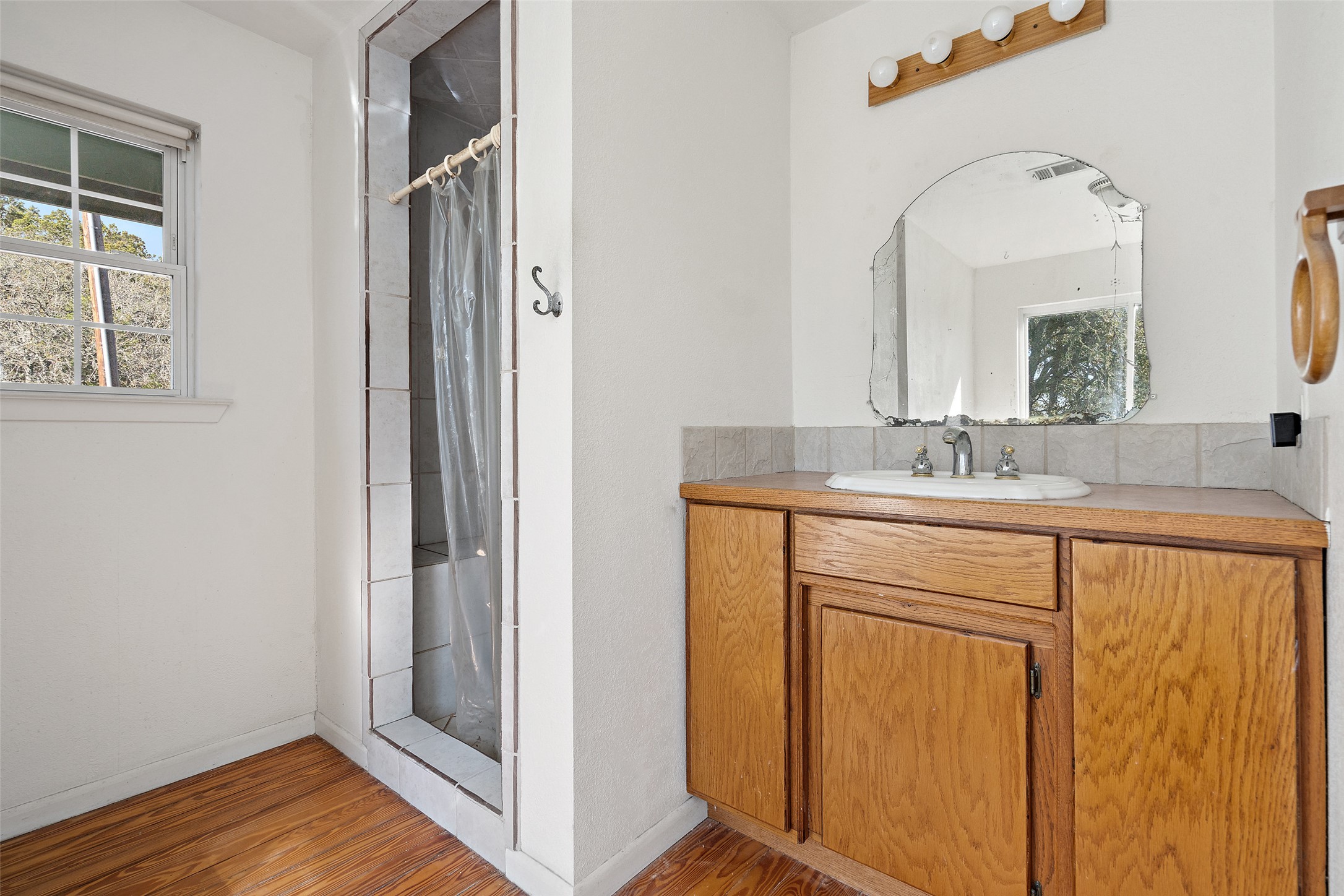 1401 Pursley Road Dripping Springs, TX 78620 - Photo 13 of 35 Primary bathroom featuring a stall shower, vanity, and light wood-style flooring