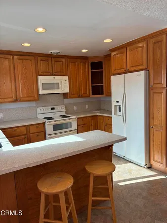 a view of a kitchen with a sink and a refrigerator