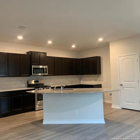 a kitchen with kitchen island stainless steel appliances a sink and a counter top