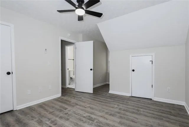 an empty room with wooden floor and ceiling fan