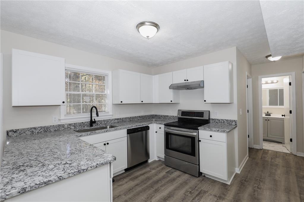 5343 Ridgemere Court Stone Mountain, GA 30083 - Photo 7 of 20 a kitchen with stainless steel appliances granite countertop a sink stove and cabinets