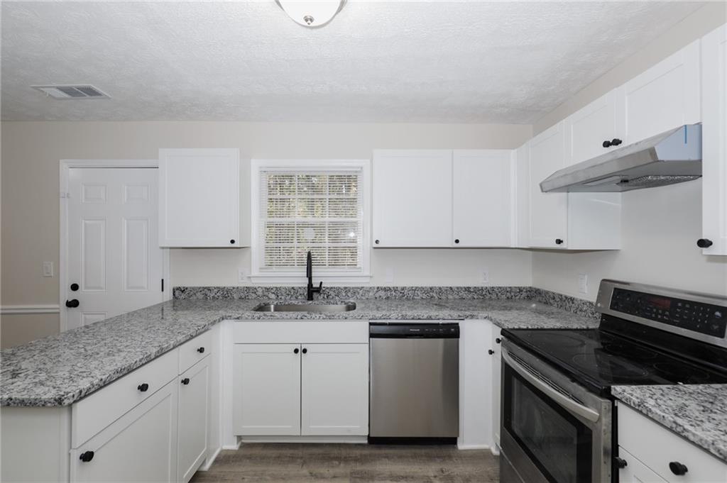 5343 Ridgemere Court Stone Mountain, GA 30083 - Photo 8 of 20 a kitchen with granite countertop a sink a stove and cabinets
