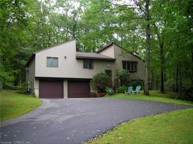 a front view of a house with a yard and trees