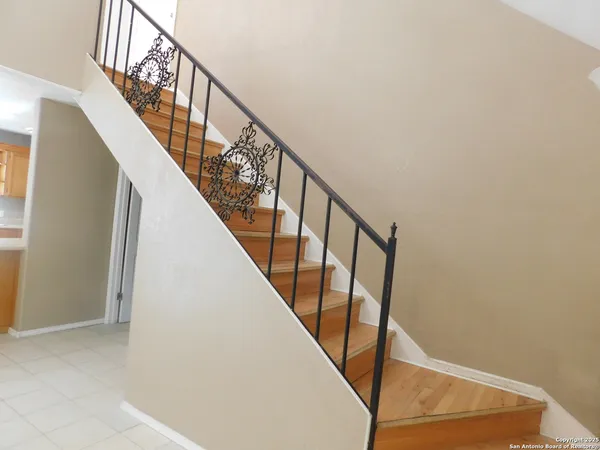 a view of staircase with wooden floor and white walls
