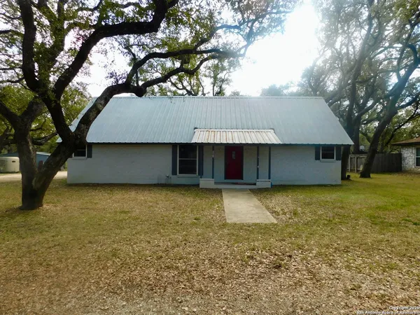 a view of an house with a yard and tree