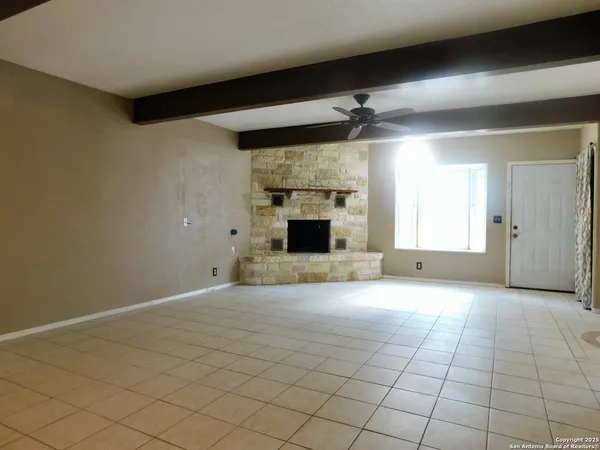 an empty room with windows and fireplace