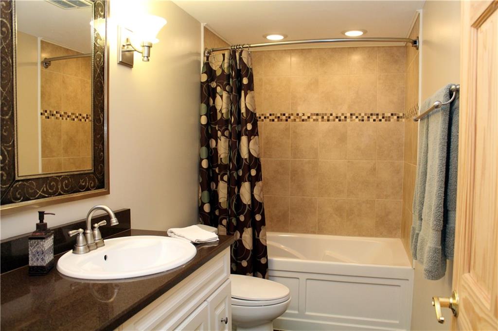 558 Partridge Run Road Gibsonia, PA 15044 - Photo 13 of 24 Updated bath has Zodiaq Quartz vanity, ceramic tile flooring & tub surround, recessed lighting above bathing area.