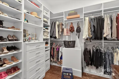 a view of walk in closet with clothes and shoes