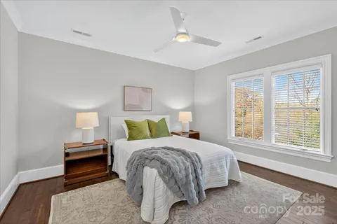 a bedroom with a bed a chandelier and a window