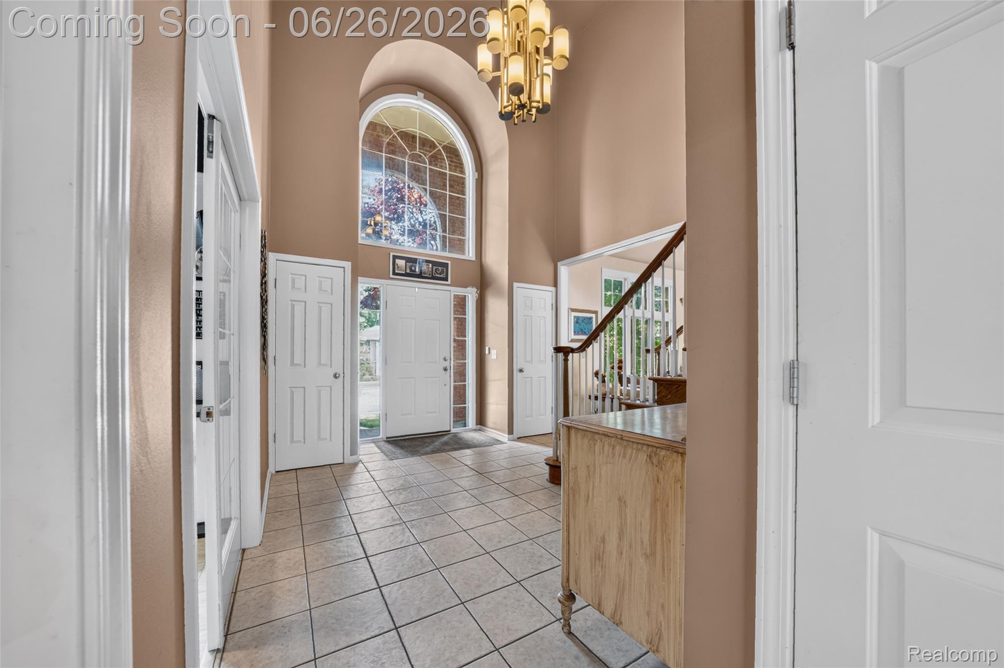 2619 Lambeth Park Rochester, MI 48306 - Photo 11 of 71 Two-story foyer featuring a grand arched window, tile flooring, a chandelier, and a staircase with white balusters