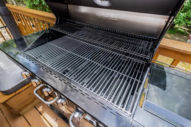 a open kitchen with stainless steel appliances granite countertop a stove a refrigerator a sink dishwasher with couches chairs and wooden floor