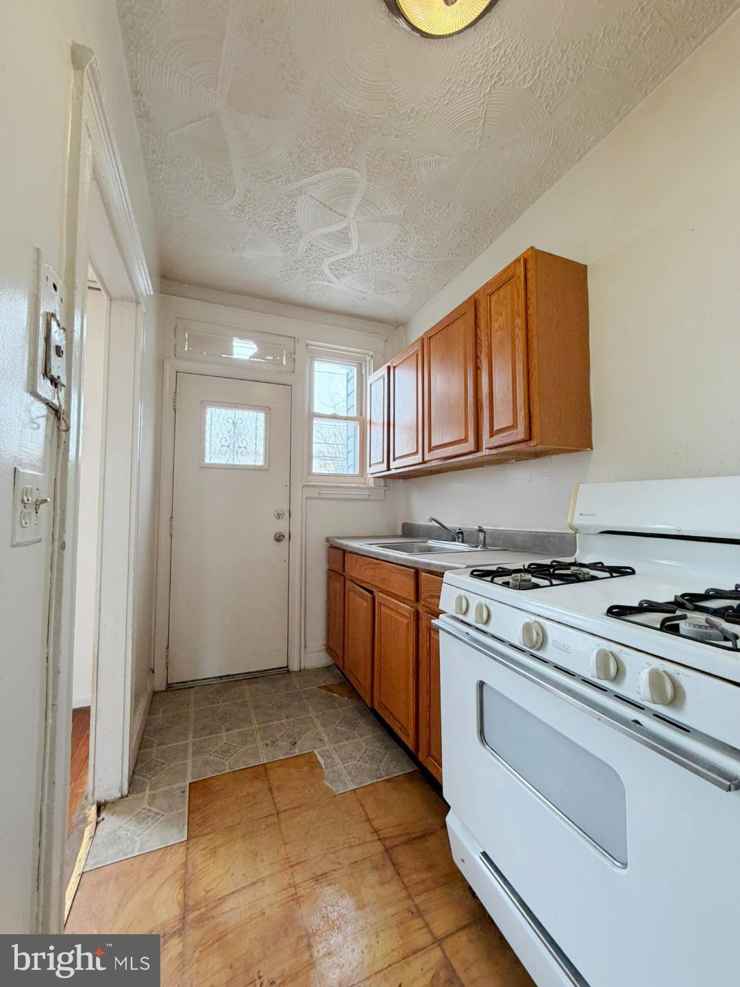 3420 Lyndale Avenue Baltimore, MD 21213 - Photo 10 of 24 a kitchen with a stove a sink and a refrigerator
