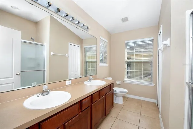 a bathroom with a sink double vanity and a toilet