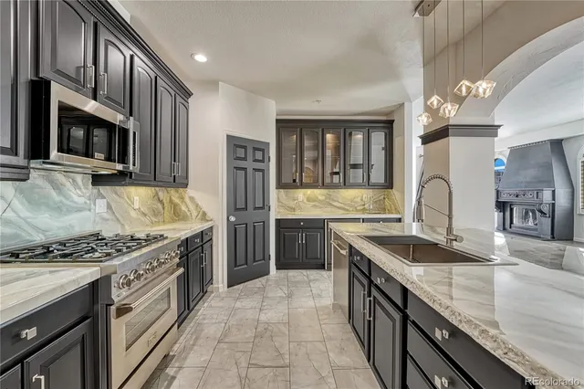 a kitchen with stainless steel appliances granite countertop a sink stove and refrigerator