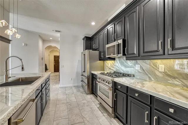 a kitchen with stainless steel appliances granite countertop a stove and a sink