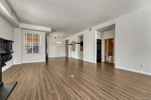 a view of empty room with wooden floor and fireplace