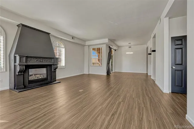 a view of a livingroom with wooden floor a fireplace and window