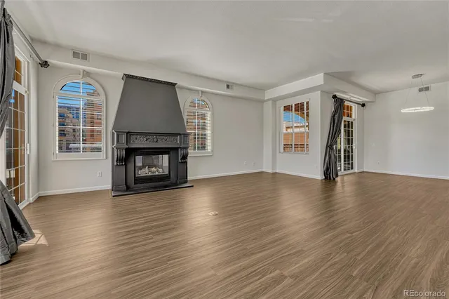 a view of empty room with fireplace and wooden floor