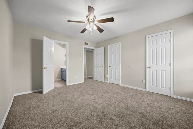 an empty room with a ceiling fan and window