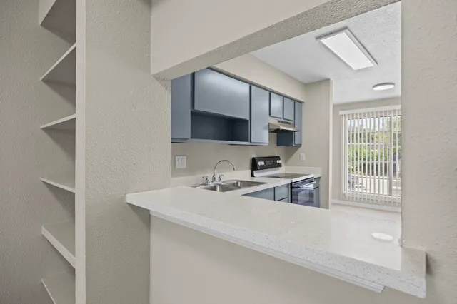 a kitchen with a sink stove and cabinets