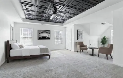 a spacious bedroom with a bed a couch and a chandelier