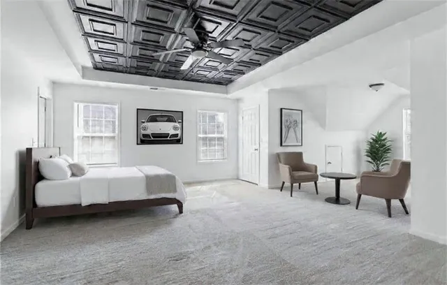 a spacious bedroom with a bed a couch and a chandelier