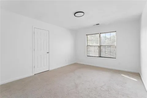 an empty room with windows and closet