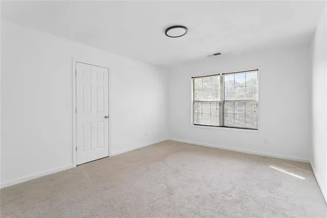 an empty room with windows and closet