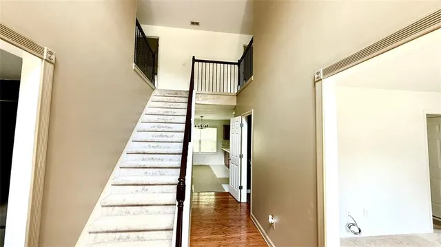a view of a hallway with wooden floor and staircase