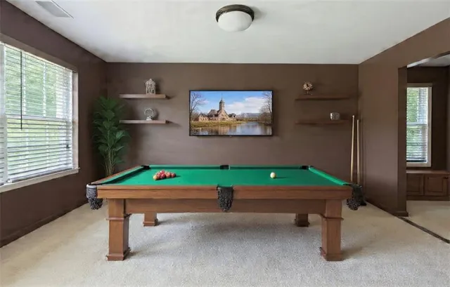 a room with pool table and windows