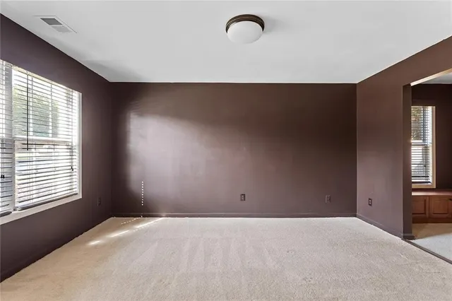 a room with a bed and windows