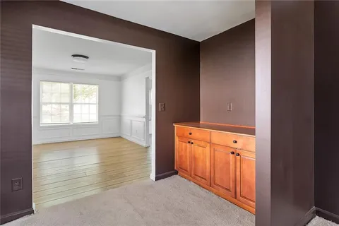a view of an empty room with window and wooden floor