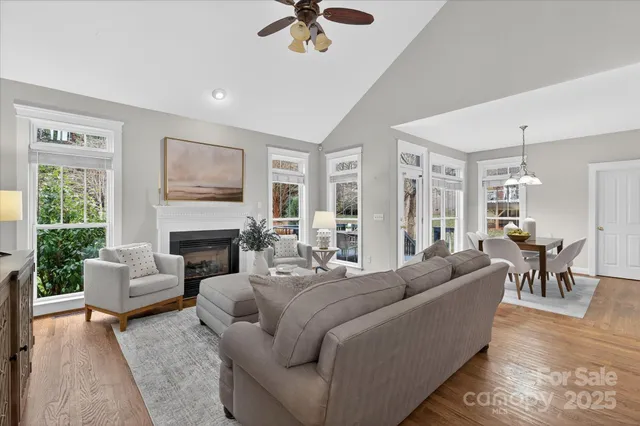 a living room with furniture fireplace and a large window