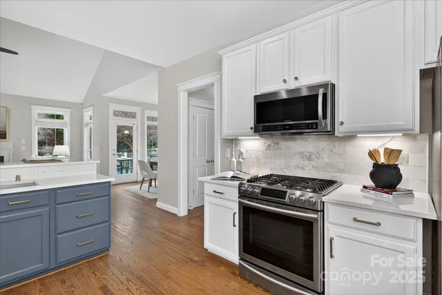 a kitchen with granite countertop a stove and a microwave