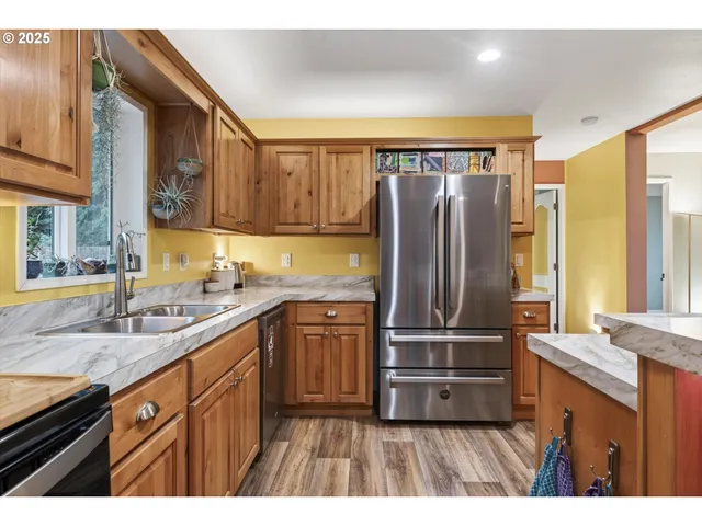 a kitchen with a sink a counter top space and living room view