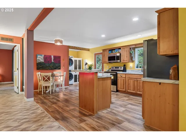 a living room with stainless steel appliances furniture a kitchen view and a kitchen view