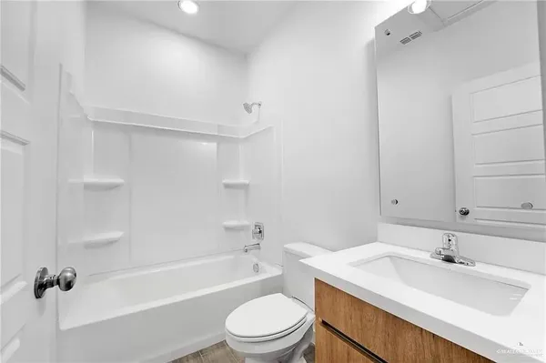 a bathroom with a granite countertop sink toilet a mirror and shower