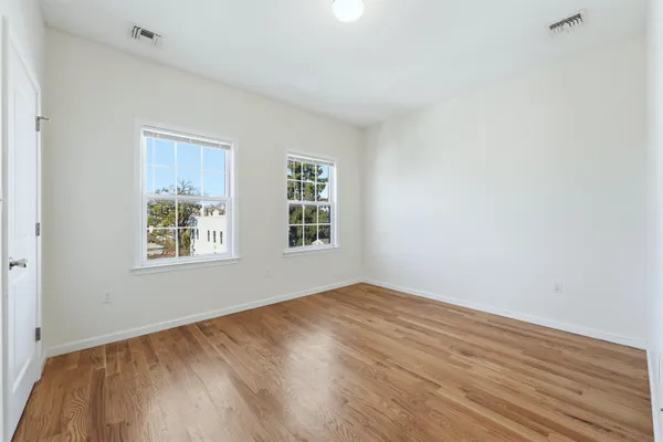 a view of an empty room with wooden floor