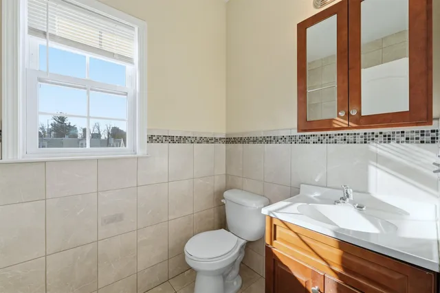 a bathroom with a toilet a sink and mirror