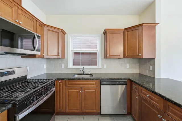 a kitchen with stainless steel appliances granite countertop a stove and a microwave
