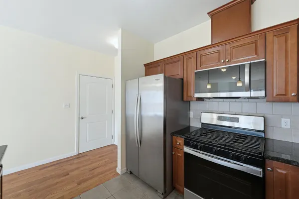 a kitchen with granite countertop a stove and a microwave