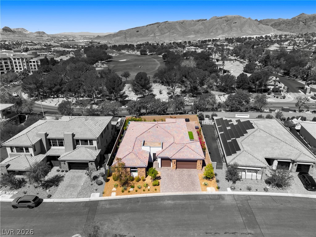 45 Garibaldi Way Henderson, NV 89011 - Photo 39 of 74 An aerial perspective reveals a vibrant neighborhood with mountain views, a golf course, and ample green space.