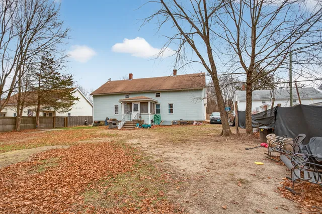 a backyard of a house with barbeque oven table and chairs