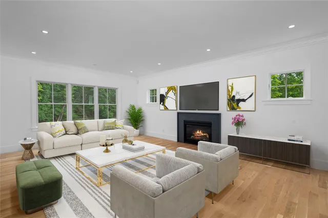 a living room with furniture a fireplace and a large window