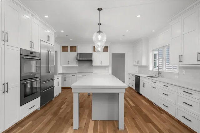 a kitchen with white cabinets stainless steel appliances and kitchen island